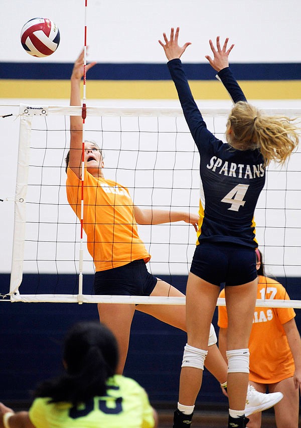 Helias's Hannah Borchelt tips the ball over the net during Tuesday night's match against Battle at Rackers Fieldhouse.