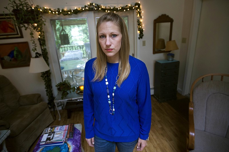 In this Sept. 22, 2017 photo, Julie Eldred poses for a photo in her Massachusetts home. Eldred, 29, tested positive for the opioid fentanyl less than two weeks after a court ordered her to refrain from drugs while on probation for larceny. She spent the next 10 days in jail until her lawyer could find her a bed in a treatment facility. On Monday, Oct. 2, 2017, Massachusetts' highest court will hear her case challenging the practice of ordering people with addiction to stay drug free as a condition of probation. (Jesse Costa/WBUR via AP)