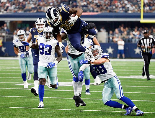 Rams running back Todd Gurley is stopped by Cowboys linebacker Jaylon Smith (rear) and safety Jeff Heath after Gurley vaulted over Heath in the second half of Sunday's game in Arlington, Texas.