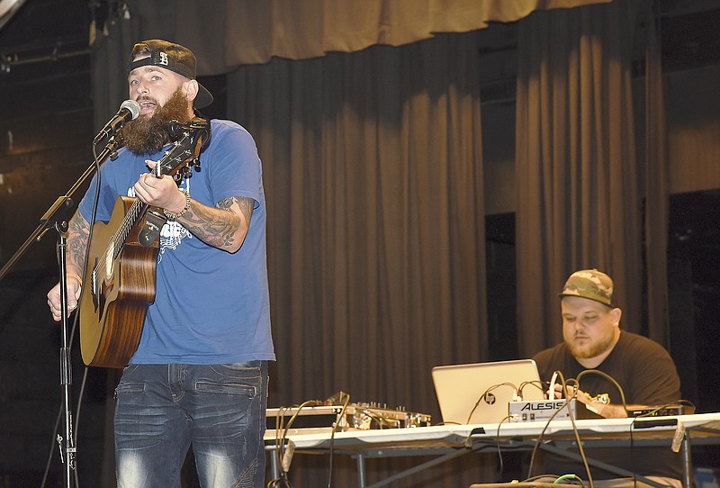 Joe Nester sings one of his songs while Chris Heinzelmann operates the sound board Tuesday during a performance at the Jefferson City High School Little Theater. They are RAW (Recovering Artists Worldwide) and Council for Drug Free Youth is sponsoring their visit this week to JCHS. RAW musicians and singers tell their story of drug addiction, being homeless and their criminal behavior until they decided it was time to sober up.