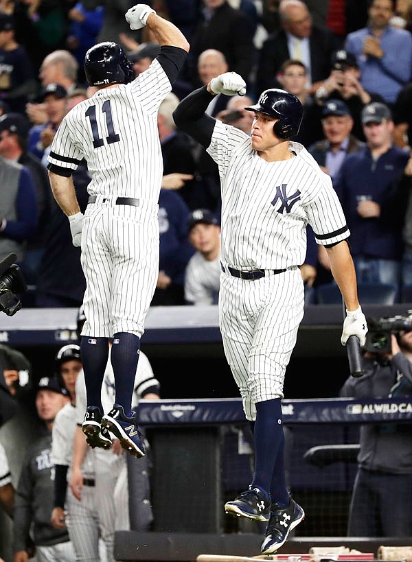 Brett Gardner (left) of the Yankees celebrates with Aaron Judge after hitting a home run during the second inning of the American League wild-card game against the Twins on Tuesday in New York.