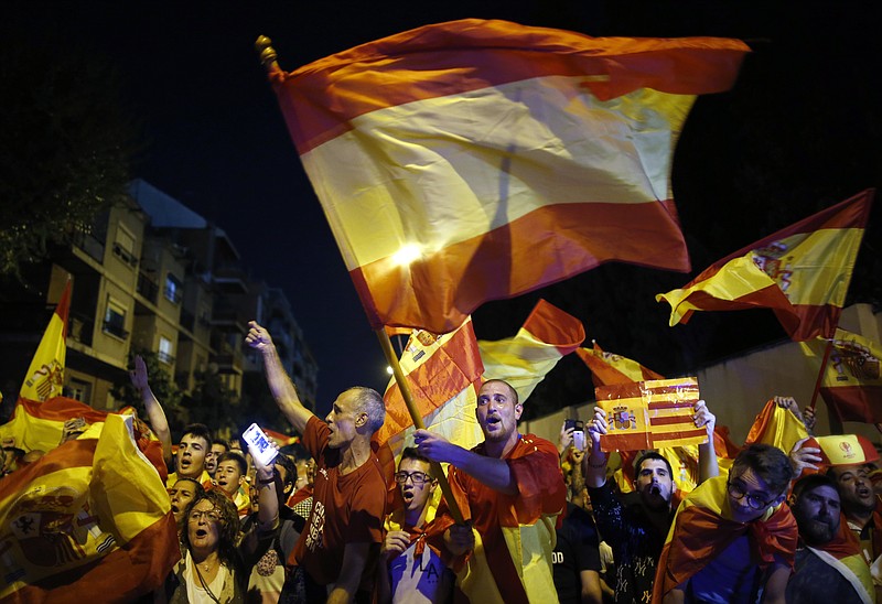 Anti-independence demonstrators wave Spanish flags in support of Spain's security forces in front of a Guardia Civil ( Civil Guard ) barracks in Sant Boi de LLobregat, in the outskirts of Barcelona, Spain, Thursday Oct. 5, 2017. The additional deployment of Spanish police forces has enraged many in Catalonia who say that officers used excessive force when cracking down on last weekend's banned independence referendum. Spain's government has praised the police response, calling it proportionate.(AP Photo/Manu Fernandez)