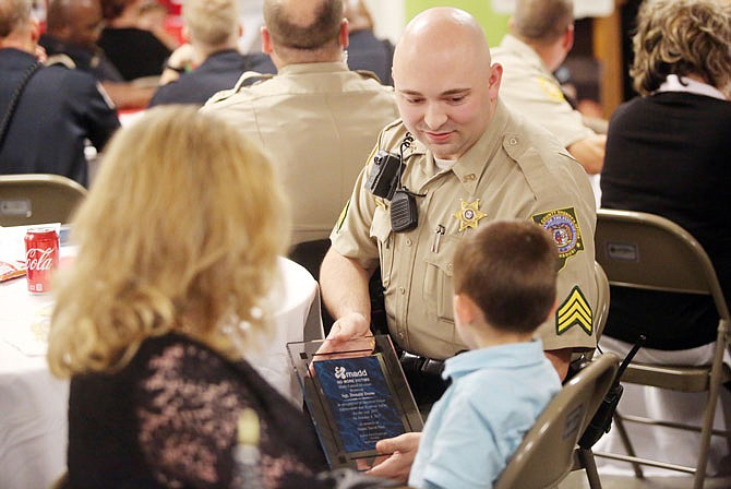 Sgt. Donald Dame, center, of the Callaway County Sheriff's Department, shows his son the plaque he received Wednesday during Central Missouri MADD's "Heroes for Heroes" event at the St. Martins Knights of Columbus Hall.