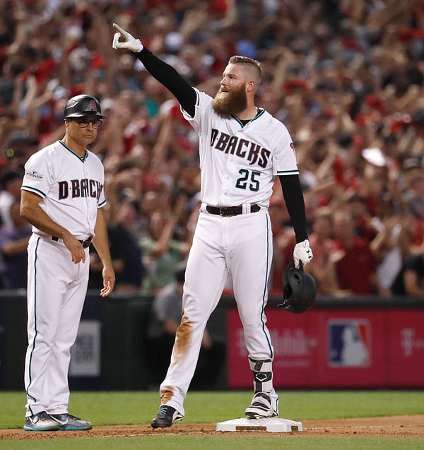 Diamondbacks relief pitcher Archie Bradley celebrate his two-run triple against the Rockies during the seventh inning of Wednesday's National League wild-card playoff game in Phoenix.