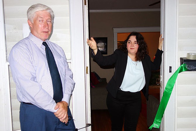 Andrea Ramos, right, director of the Student Office of Sustainability at Westminster College, welcomes visitors into EcoHouse's new office. She and Vice President of Campus Operations Dan Haslag cut the ribbon Tuesday to open the space.