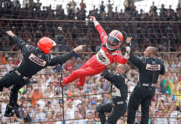 In this May 24, 2009, file photo, Helio Castroneves climbs the safety fence with members of his pit crew after winning the Indianapolis 500. Castroneves will move to Team Penske's sports car program next season, bringing his 20-year full-time IndyCar career to an end.