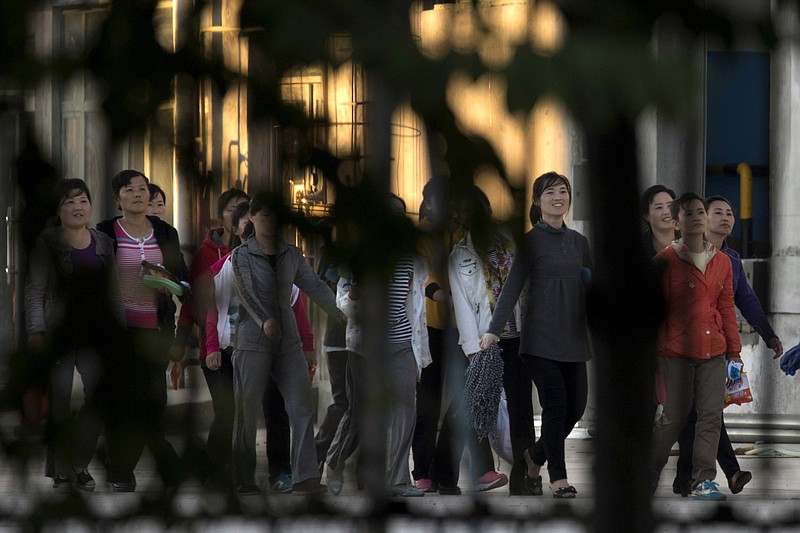 In this Aug. 31, 2017, photo, North Korean workers walk in a group to dormitories in the compound of the seafood processing factory Hunchun Pagoda in the city of Hunchun in northeastern China's Jilin province. Roughly 3,000 North Koreans are believed to work in Hunchun, a far northeast Chinese industrial hub just a few miles from the borders of both North Korea and Russia. The workers are paid a fraction of their salaries, while the rest - as much as 70 percent - is taken by North Korea’s government. (AP Photo/Ng Han Guan)