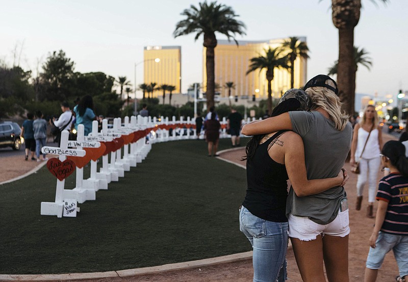 A memorial displaying 58 crosses by Greg Zanis stands at the Welcome To Las Vegas Sign on Thursday, October 5, 2017, in Las Vegas. Each cross has the name of a victim killed during the mass shooting at the Route 91 Harvest country music festival this past Sunday. Dozens of people were killed and hundreds were injured.  (Mikayla Whitmore/Las Vegas Sun via AP)