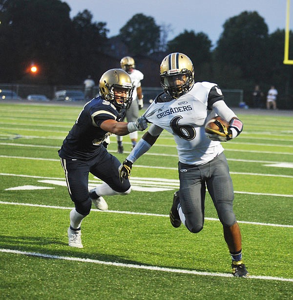 Jacob Weaver of Helias tries to bring down an Althoff ball carrier during a game this season at Ray Hentges Stadium.