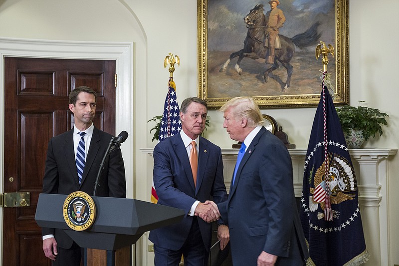 President Donald Trump shakes hands with Sen. David Perdue (R-Ga.) during an announcement on the introduction of the Reforming American Immigration for a Strong Economy Act on August 2, 2017, in the Roosevelt Room at the White House in Washington, D.C. At left is Sen. Tom Cotton (R-Ark). 