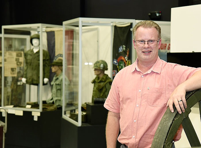 Charles Machon poses in front of two Vietnam War displays at the Museum of Missouri Military History, where he is director.