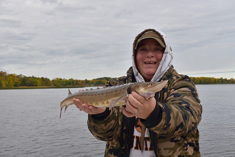 Lotte Houser is all smiles just before releasing the first sturgeon she's ever caught from the Rainy River near Sportsman's Lodge in Minnesota.