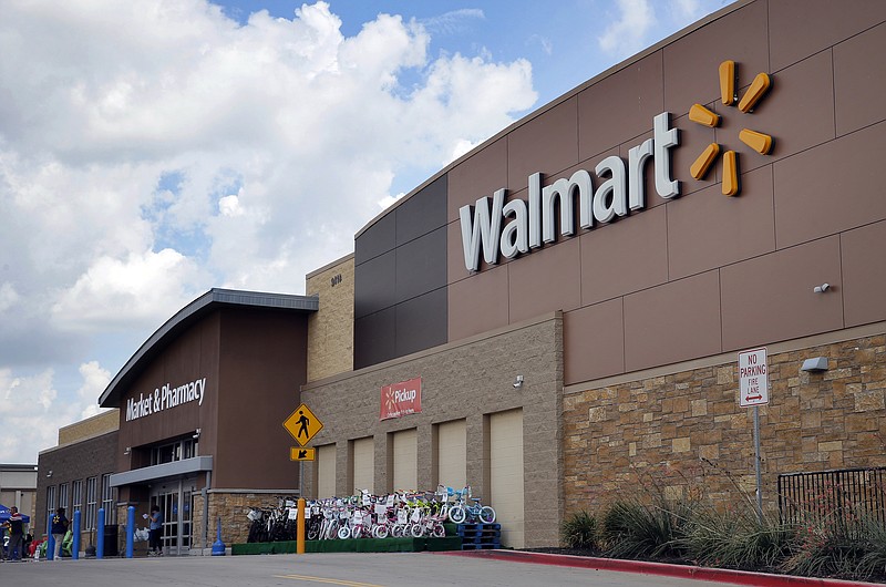 FILE - In an Aug. 26, 2016, file photo, people walk in and out of a Walmart store, in Dallas. Walmart announced new moves Monday, Oct. 9, 2017, to speed up the return process for online purchases, including letting some shoppers keep the stuff they don’t want and still get a refund. (AP Photo/Tony Gutierrez, File)