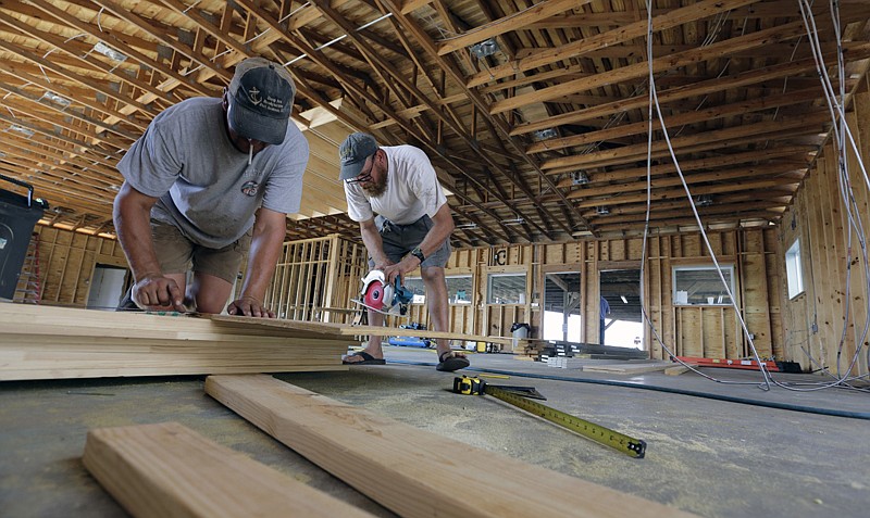 James Wheeler Jr., right, works to help rebuild his fishing business, Deep Sea Headquarters, on Sept. 29 in Port Aransas, Texas. Wheeler would normally be leading deep-sea fishing excursions, has been pressed into service as an amateur builder working to rebuild what was destroyed by Hurricane Harvey. 