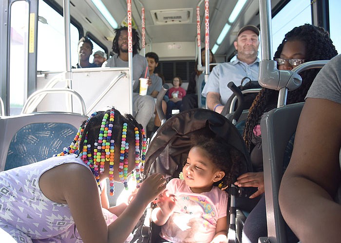 Timeka Towne, right, keeps an eye on her daughters, Allani, 7, and Lyrik, 2, as they play while riding a JeffTran bus Monday on customer appreciation day. Towne said she avails herself of the service on a regular basis and the girls seem to enjoy the trip.