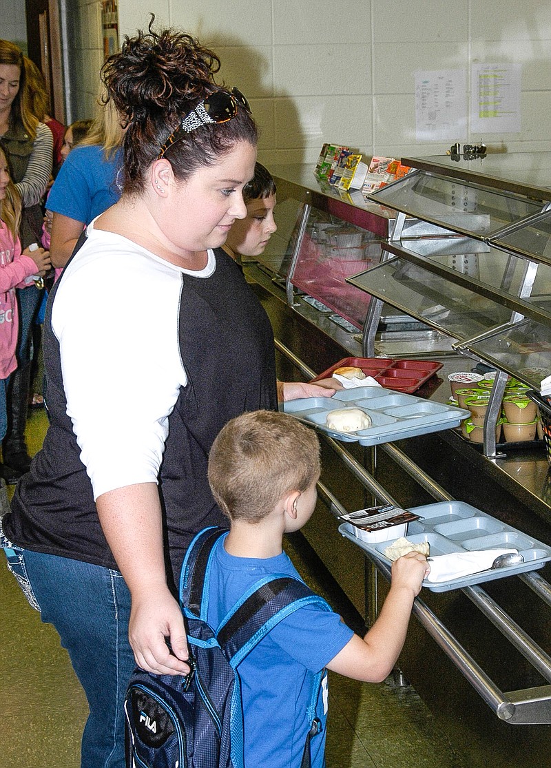 Finn Gunnerson, with Ronessa Gunnerson, fill their breakfast trays at California Elementary School's "Muffins for Moms" event Oct. 4. (Democrat photo / David A. Wilson)
