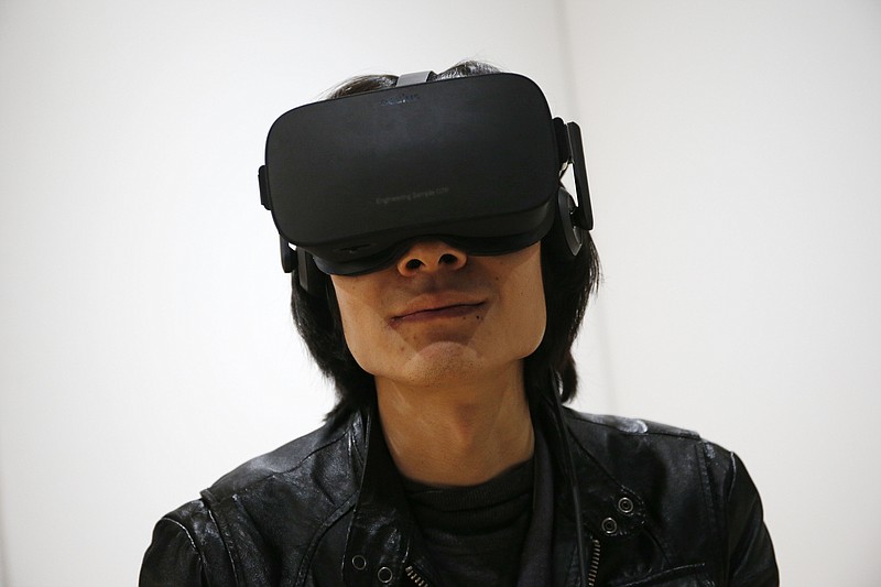 <p>AP</p><p>Peijun Guo wears the Oculus Rift VR headset at the Oculus booth at CES International in Las Vegas.</p>