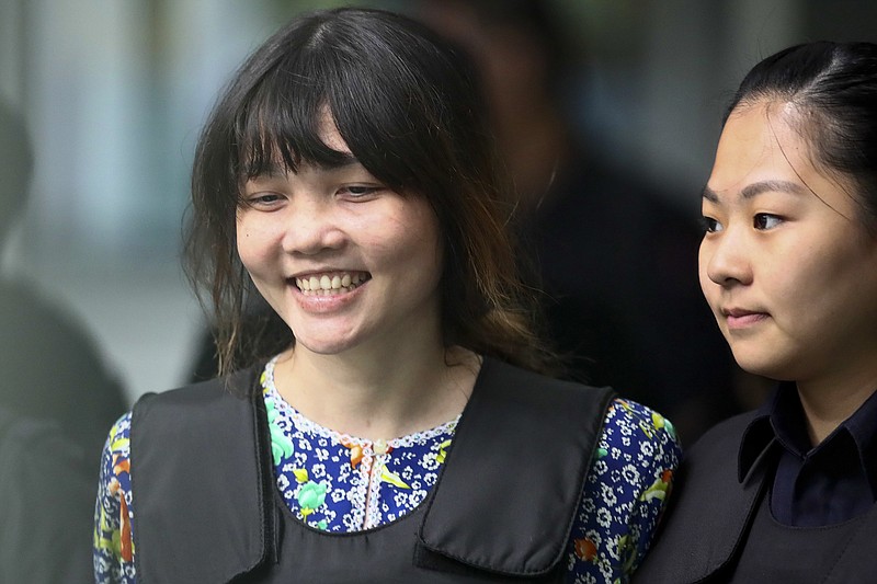 Vietnamese Doan Thi Huong, left, is escorted by police as she leaves after the court hearing at the Shah Alam court house in Shah Alam court house in Shah Alam, outside Kuala Lumpur, Malaysia Wednesday, Oct. 11, 2017. Security videos were presented at the murder trial Wednesday showing the estranged half brother of North Korea's leader being attacked at a Malaysian airport and the two suspects hurrying away afterward. (AP Photo/Sadiq Asyraf)