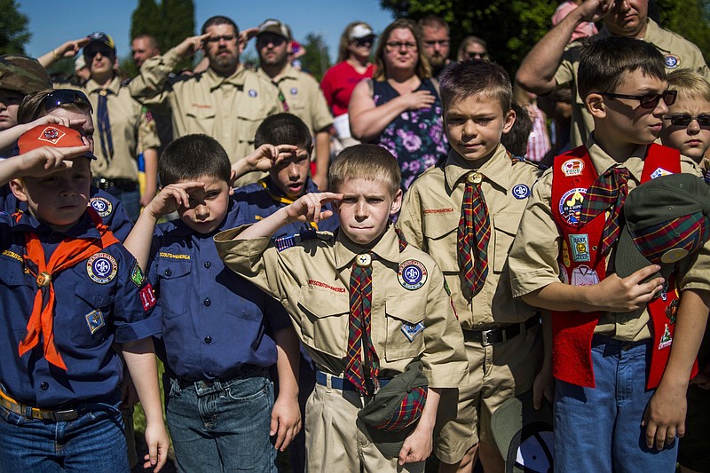 In this Monday, May 29, 2017, file photo, Boy Scouts and Cub Scouts salute during a Memorial Day ceremony in Linden, Mich. On Wednesday, Oct. 11, 2017, the Boy Scouts of America Board of Directors unanimously approved to welcome girls into its Cub Scout program and to deliver a Scouting program for older girls that will enable them to advance and earn the highest rank of Eagle Scout.