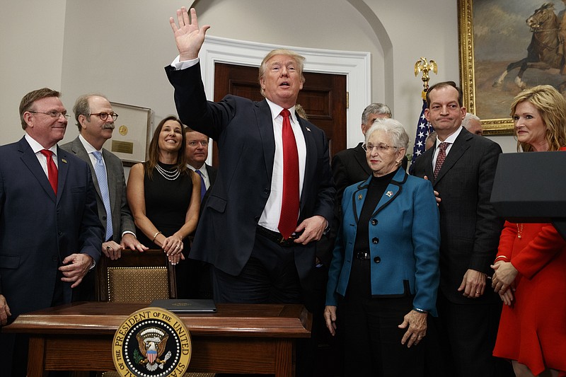 President Donald Trump waves after signing an executive order on health care in the Roosevelt Room of the White House, Thursday, Oct. 12, 2017, in Washington. (AP Photo/Evan Vucci)