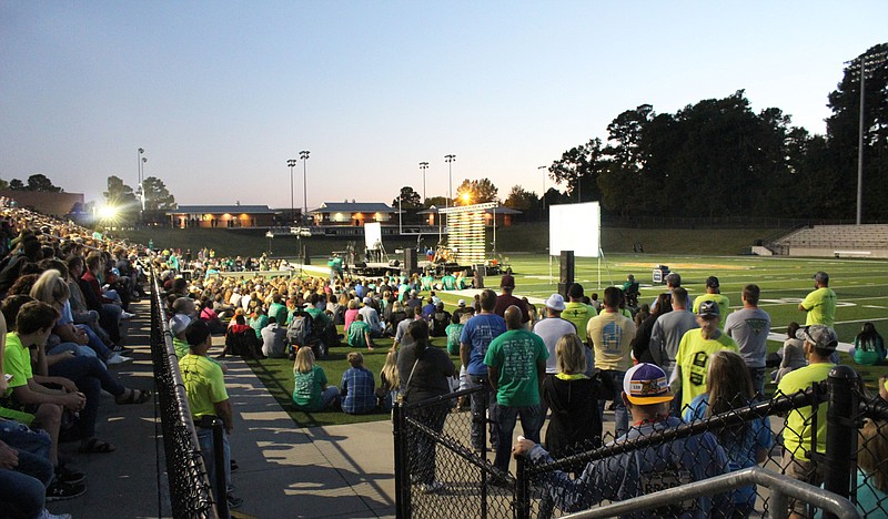 A crowd listens to a speaker during the Fields of Faith event at Hawk Stadium on Wednesday night.