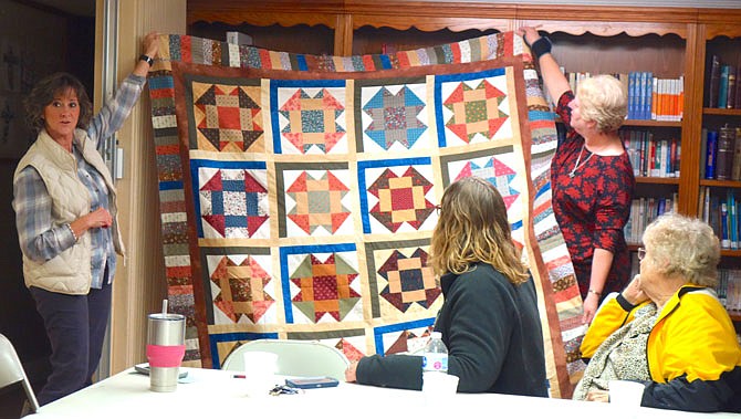 Debra Salmons, left, and Susan Ward present the September friendship quilt to the Country Friends Quilt Club on Wednesday evening. Members contributed 13 of the 16 square