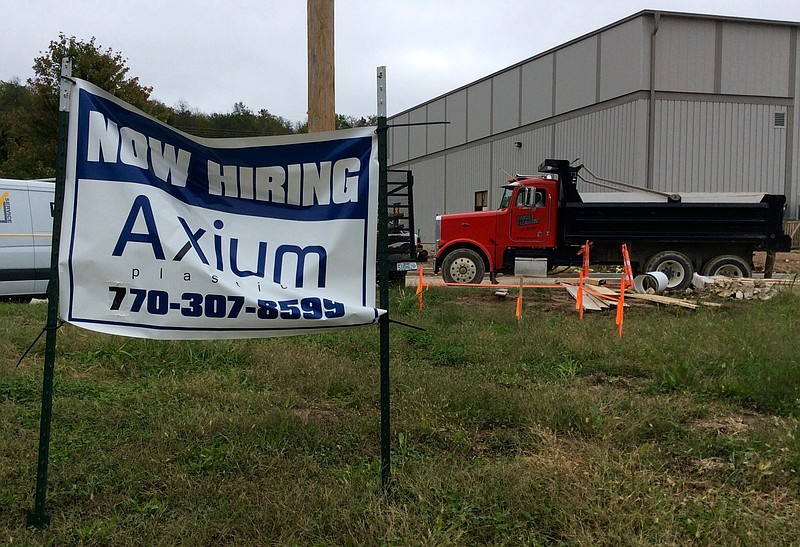 This Oct. 13, 2017 photo shows a "now hiring" sign outside the Axium Plastics facility in eastern Jefferson City.