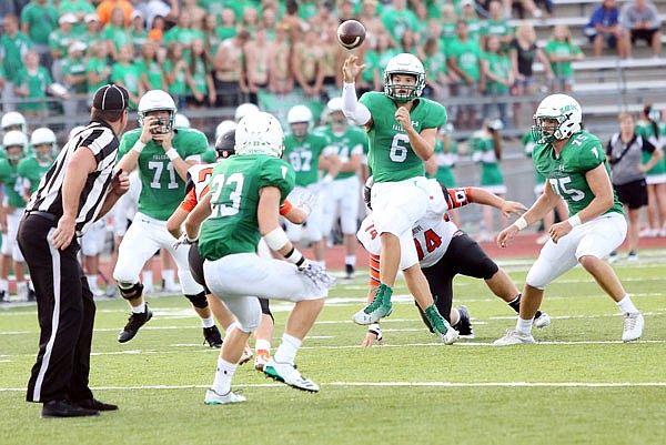 Blair Oaks quarterback Nolan Hair (center) throws a pass to wide receiver Ethan Luebbering (left) during a game earlier this season against Oak Grove at Wardsville. Hair is expected to start tonight at Warsaw after missing the past five games due to a lower right leg injury.