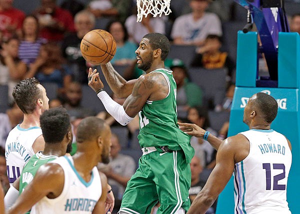 Celtics guard Kyrie Irving drives past Dwight Howard (right) of the Hornets in the second half of Wednesday's preseason game in Charlotte, N.C. Irving will be back in Cleveland on Tuesday to face his former team.