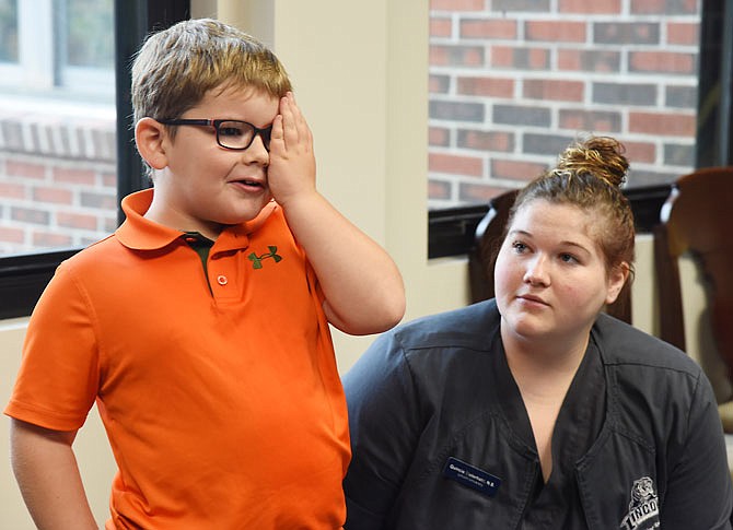 Lincoln University nursing student Quincie Eisterhold watches as John Hamilton covers his left eye Thursday to read letters on a vision chart during a health screening. In a first-time collaboration, St. Martin Elementary School invited nursing students to give the screenings as a way to get all of the students screened in a short time and for the nursing students to get practical experience out of the classroom. 