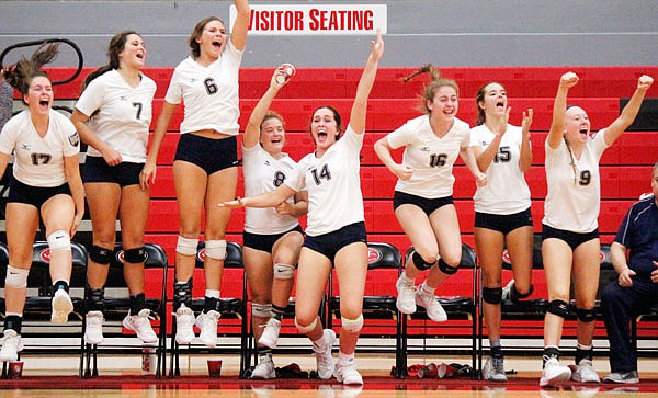 Helias middle hitter Grace Millard (center) celebrates with the rest of her teammates on the bench following a point scored by the Lady Crusaders during their match Thursday night against the Jefferson City Lady Jays at Fleming Fieldhouse.