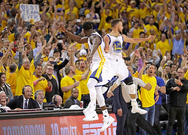 In this June 12 file photo, Warriors forward Draymond Green (left) and guard Stephen Curry celebrate during the second half of Game 5 of the NBA Finals against the Cavaliers in Oakland, Calif. The Warriors are the favorite to win the championship again.