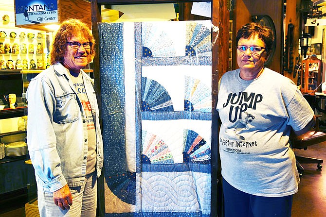 Virginia Eckert, left, Linda Schotte and other members of the Williamsburg Ladies Club worked to finish this fan quilt started by another club member. The quilt will be raffled Wednesday to raise money for scholarships to be given to North Callaway High School seniors.