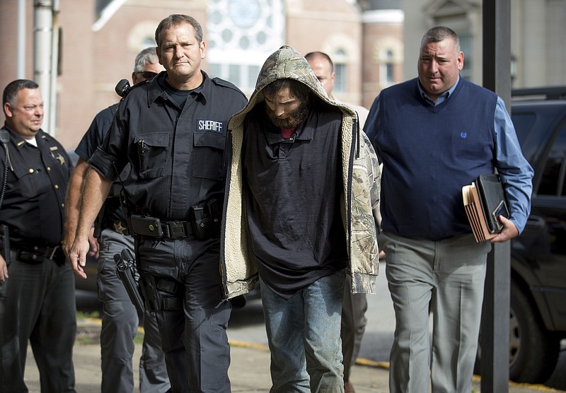 Lawrence County Sheriff Jeff Lawless escorts in Arron Lee Lawson after he was captured on Friday, Oct. 13, 2017, in Ironton, Ohio. Lawson has been arrested on three counts of murder and one count of aggravated murder.(Sholten Singer/The Herald-Dispatch via AP)