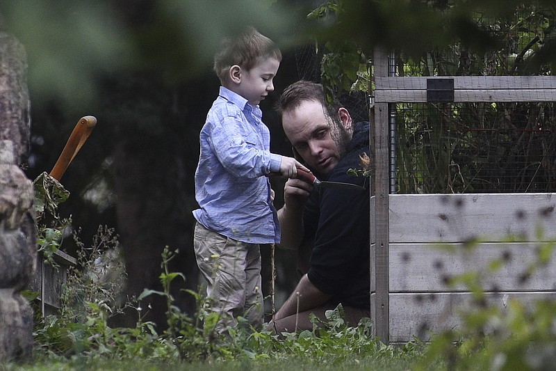 ADDS NAME OF SON JONAH- Joshua Boyle and son Jonah play in the garden at his parents house in Smiths Falls, Ont., on Saturday, Oct. 14, 2017. A couple held hostage for five years by a Taliban-linked network and forced to raise three children while in captivity were initially targeted for ransom because of the impending birth of their first child, the Canadian man at the heart of the case speculated Saturday. Boyle said he and his wife Caitlan Coleman heard at least half a dozen reasons why they had been snatched from a village in Afghanistan and held against their will by the Haqqani network over the years they were imprisoned. (Lars Hagberg/The Canadian Press via AP)