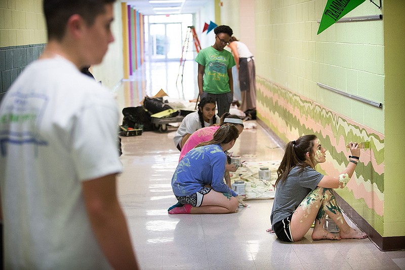Seagan Powell and other Pleasant Grove ninth-grade art students put the finishing touches on the first part of a design project Friday at PG Elementary School. 