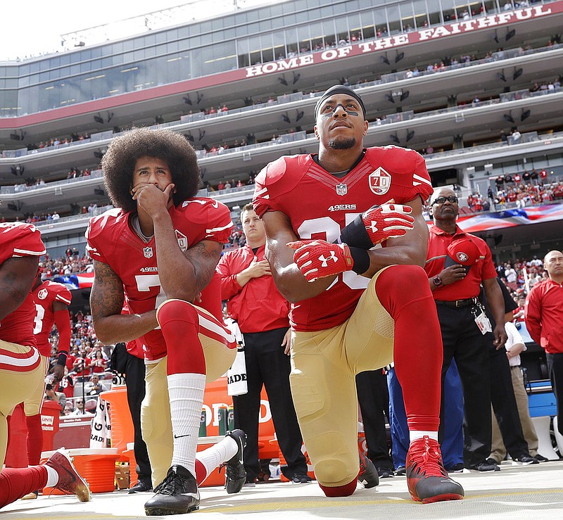 In this Oct. 2, 2016 file photo, San Francisco quarterback Colin Kaepernick, left, and safety Eric Reid kneel during the national anthem before an NFL football game against the Dallas Cowboys in Santa Clara, Calif. 