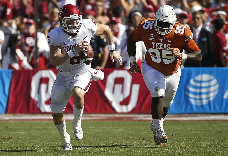 Oklahoma quarterback Baker Mayfield (6) scrambles for a first down as Texas defensive lineman Poona Ford (95) pursues during the first half of an NCAA college football game Saturday, Oct. 14, 2017, in Dallas, Texas. 