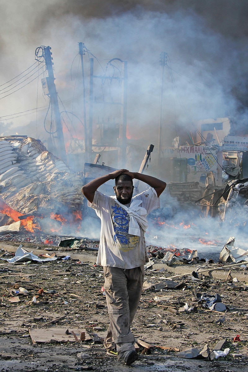 A man walks past destroyed buildings Saturday at the scene of a blast in Mogadishu, Somalia. 
