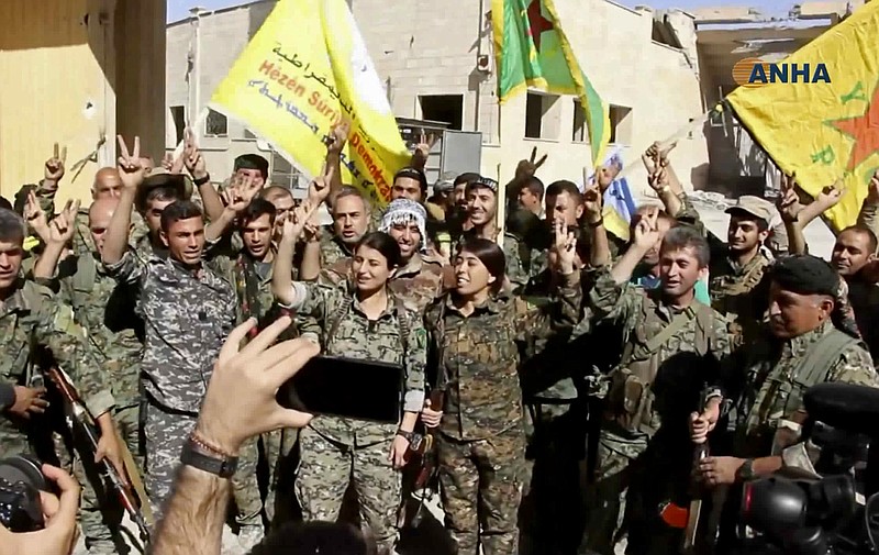 This frame grab from video released Tuesday, Oct. 17, 2017 and provided by Hawar News Agency, a Syrian Kurdish activist-run media group, shows fighters from the U.S.-backed Syrian Democratic Forces (SDF) celebrating their victory in Raqqa, Syria. U.S.-backed Syrian forces liberated the city of Raqqa from Islamic State militants on Tuesday, a senior commander for the force said, adding that clearing operations were underway to remove land mines left behind and search for the extremist group's sleeper cells. (Hawar News Agency via AP)