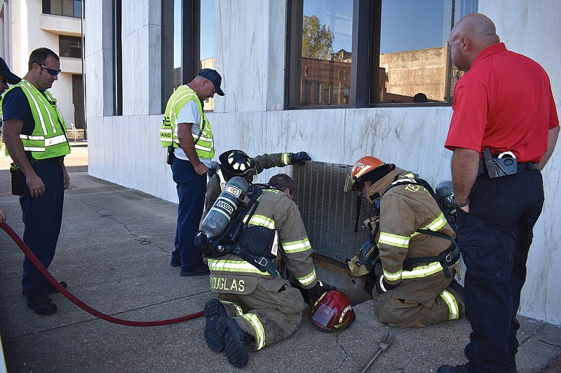 Texarkana, Texas, firefighters lower a smoke ejector into the basement of the former Capitol One Bank building to remove smoke. Texas-side Fire Marshall Chuck Weerts said the fire department received a call about 5 p.m. Monday regarding a small fire in the building's basement, but at press time they were unable to determine the fire's cause.