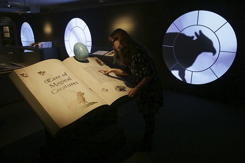 A member of British Library staff poses for a picture at the "Harry Potter - A History of Magic" exhibition at the British Library, in London, Wednesday Oct. 18, 2017.  The exhibition running from Oct. 20, marks the 20th anniversary of the publication of Harry Potter and the Philosopher's Stone, showing items from the British Library's collection, and items from author J.K Rowling and the book publisher's collection.  (AP Photo/Tim Ireland)