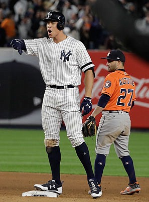 Aaron Judge of the Yankees celebrates in front of Astros second baseman Jose Altuve after hitting an RBI double during the eighth inning of Tuesday's game in New York