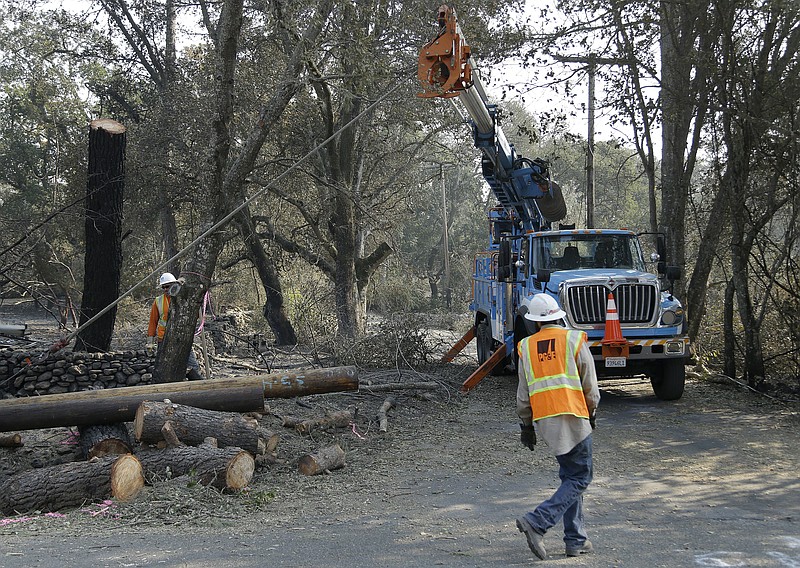 A Pacific Gas & Electric crew work on replacing poles Wednesday, Oct. 18, 2017, in Glen Ellen, Calif. California fire officials have reported significant progress on containing wildfires that have ravaged parts of Northern California. (AP Photo/Ben Margot)