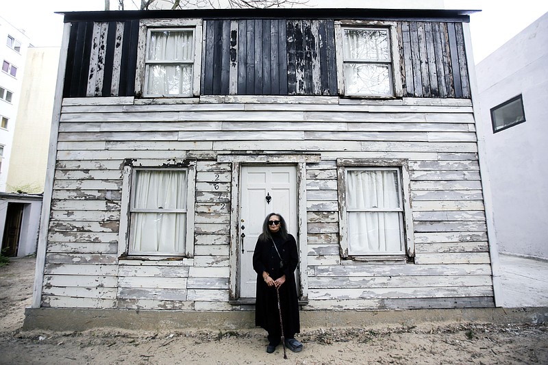 FILE - In this April 6, 2017 file photo, Rhea McCauley, a niece of the late civil rights activist Rosa Parks, poses in front of the rebuilt house of Rosa Parks in Berlin. McCauley donated the house, originally located in Detroit, to American artist Ryan Mendoza who dismantled and and rebuilt it in the German capital. Brown University said in October it is looking to temporarily relocate the house from Berlin to Providence, R.I. (AP Photo/Markus Schreiberl, File)