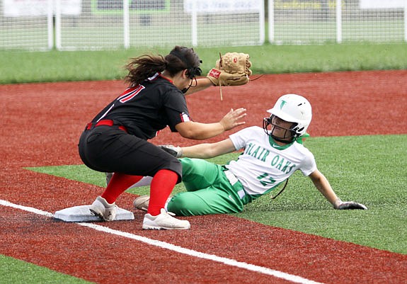 Kayla Jones of Blair Oaks slides safely under the tag from Eugene third baseman Hannah Rader during the district title game earlier this month in California.