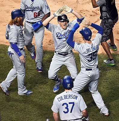 Enrique Hernandez (center) celebrates his third-inning grand slam with his Dodger teammates during Thursday night's game against the Cubs in Chicago.