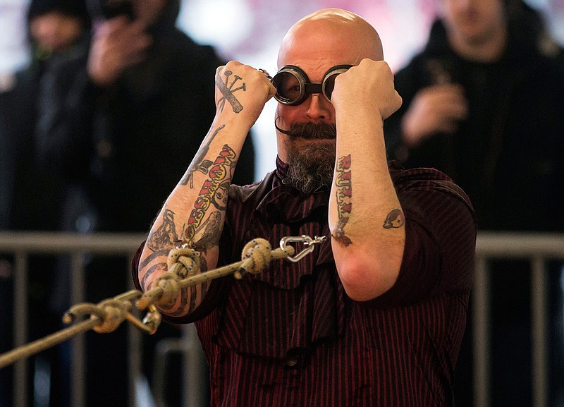 "Burnaby Q. Orbax," of the sideshow duo The Monsters of Schlock, stands in place while being pulled by a motorcycle with ropes attached to hooks inserted in the flesh of his arms, while participating in a tug of war stunt with his partner "Sweet Pepper", in Vancouver, British Columbia, on Wednesday, Oct. 18, 2017. The pair are marking their 10th year of performing at Fright Nights at Playland.
