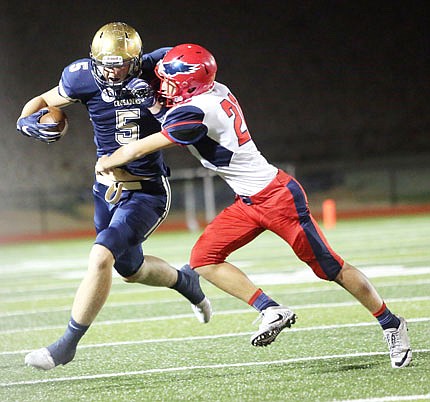 Helias wide receiver Nathan Bax tries to elude a tackle against a Liberty: Wentzville defender during Friday night's district game at Ray Hentges Stadium.