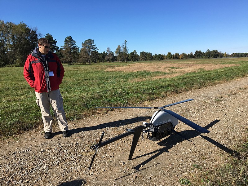 In this Oct. 17, 2017 photo, Nick Brown, a drone pilot for Pulse Aerospace of Lawrence, Kan., stands beside a Pulse Vapor unmanned aircraft at Griffiss International Airport in Rome, N.Y. New York is investing $30 million in a 50-mile drone testing corridor between Rome and Syracuse for drone research and development. (AP Photo/Mary Esch)